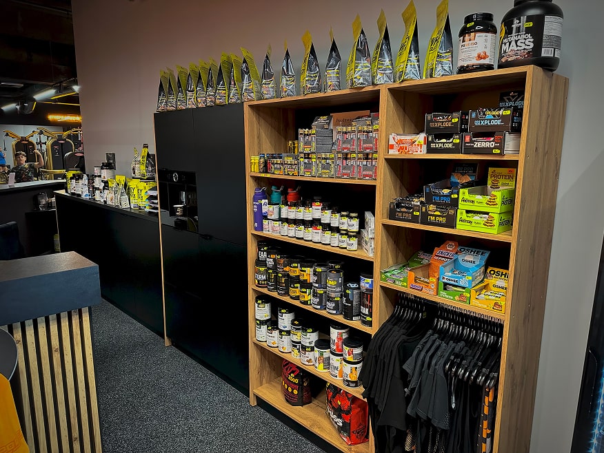 Recepcja klubu XPower z barem, ekspozycją suplementów oraz ubraniami na sprzedaż.